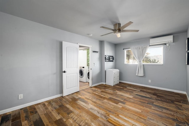 unfurnished bedroom with washer and dryer, a wall unit AC, ceiling fan, and dark hardwood / wood-style flooring