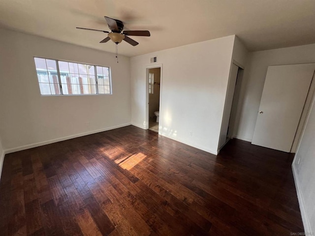 spare room featuring dark wood-type flooring and ceiling fan