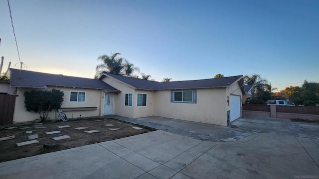 ranch-style house with a patio area and a garage