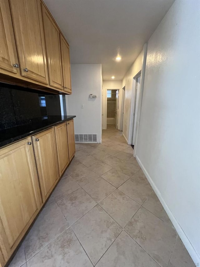 kitchen featuring dark stone countertops and light tile patterned floors