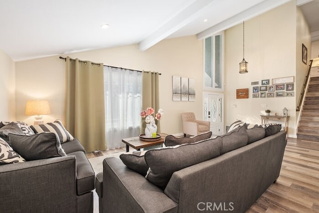 living room with hardwood / wood-style flooring and vaulted ceiling with beams