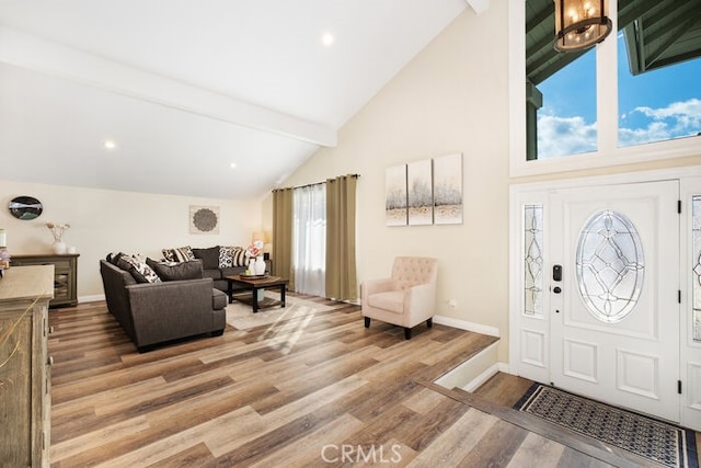 foyer with a healthy amount of sunlight, hardwood / wood-style floors, and beamed ceiling