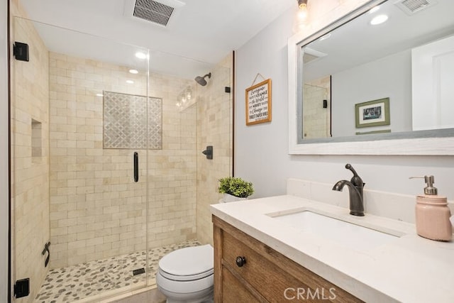 bathroom with toilet, vanity, and walk in shower