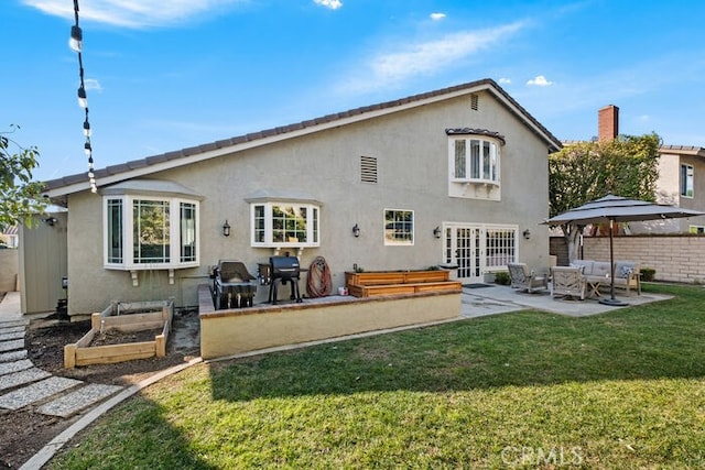 back of property with a patio area, a gazebo, french doors, and a yard