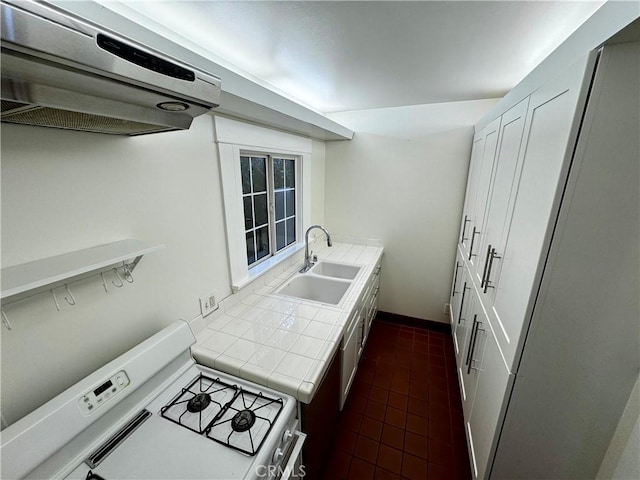 kitchen featuring tile countertops, white cabinetry, ventilation hood, white gas range oven, and sink