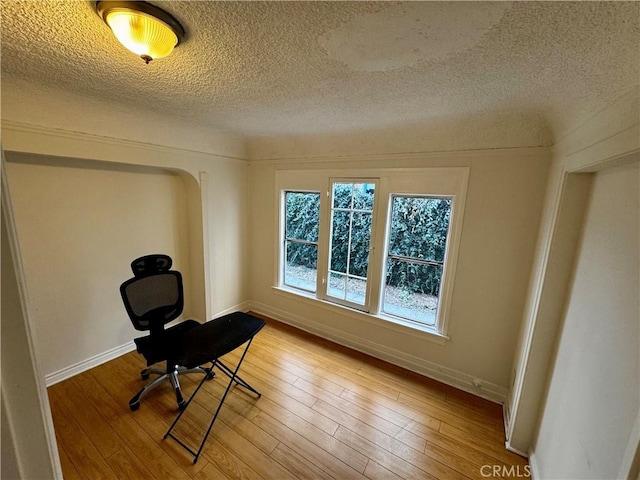 interior space featuring a textured ceiling and hardwood / wood-style floors