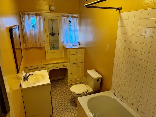 bathroom featuring toilet, vanity, a bathing tub, and tile patterned flooring