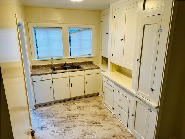 kitchen featuring white cabinets and sink