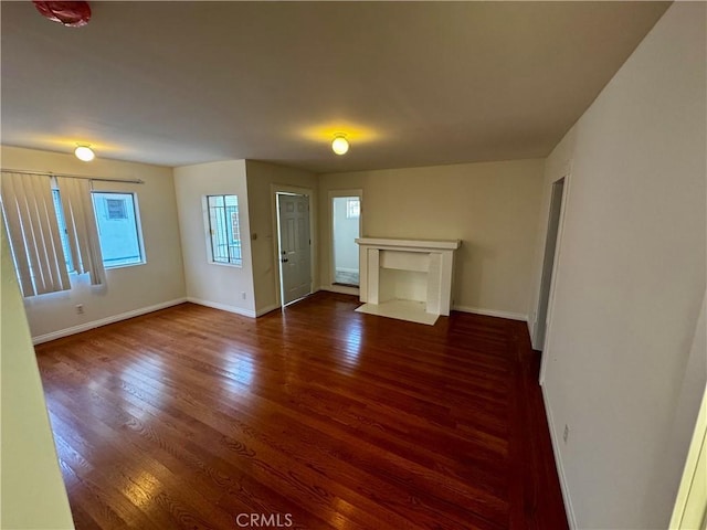 unfurnished living room with dark wood-type flooring