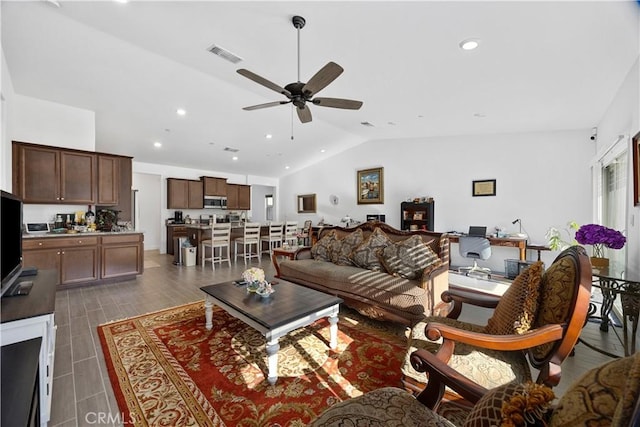 living room featuring ceiling fan and vaulted ceiling