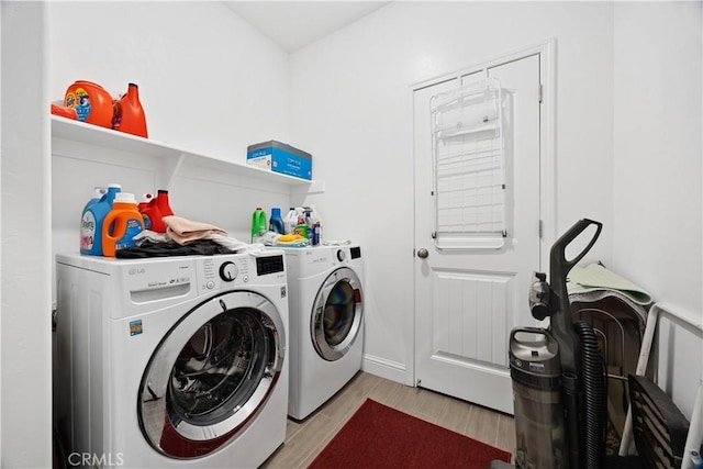 washroom with washing machine and dryer and light hardwood / wood-style flooring