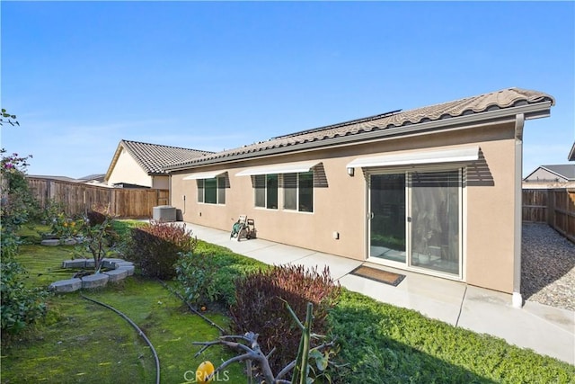 back of house featuring a patio area and a yard