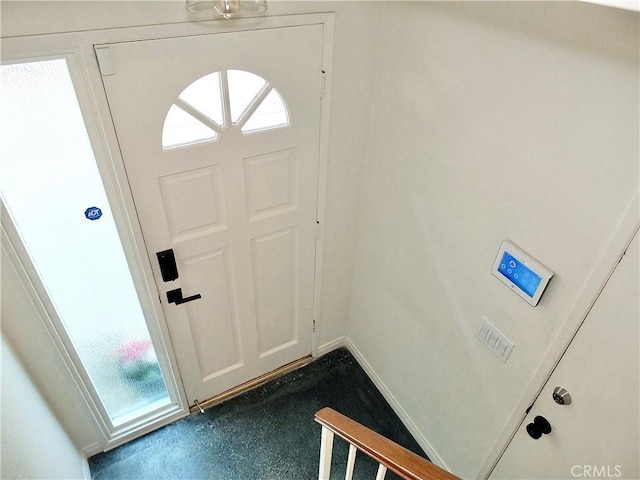 foyer entrance featuring baseboards and finished concrete floors