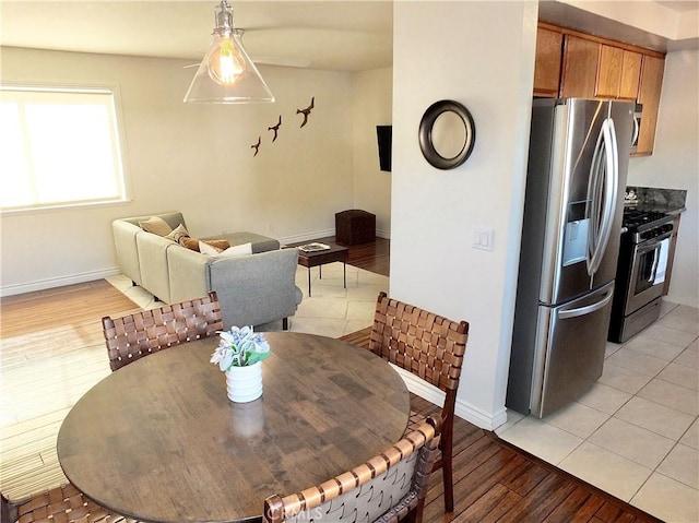 dining space featuring light wood-type flooring, baseboards, and a baseboard heating unit