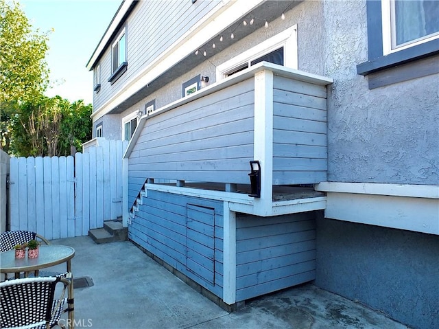 view of property exterior featuring a patio area and fence