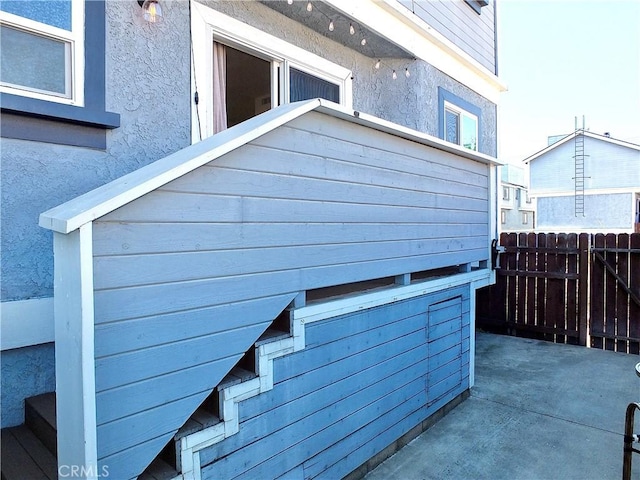 exterior space featuring fence and stucco siding