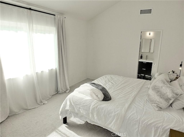 bedroom with lofted ceiling, visible vents, and carpet floors