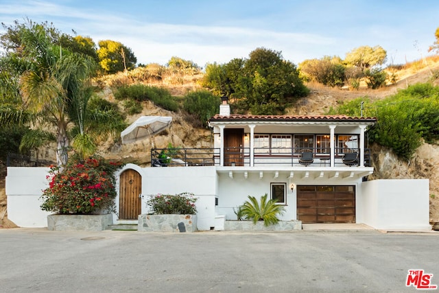 mediterranean / spanish-style house with a balcony and a garage