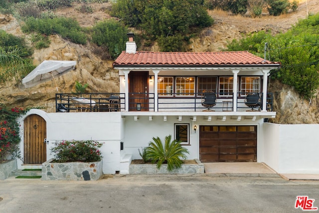 mediterranean / spanish-style house with a balcony and a garage