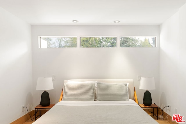 bedroom featuring hardwood / wood-style floors and multiple windows