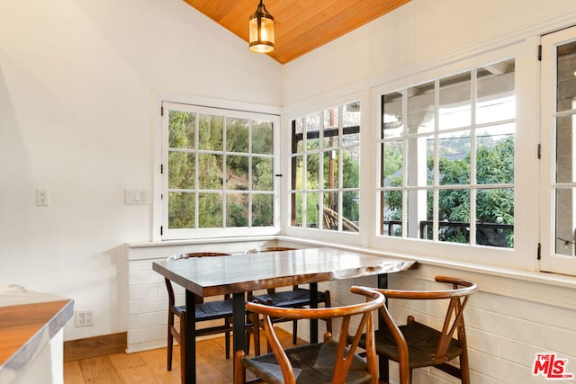 dining space featuring a wealth of natural light, vaulted ceiling, and light hardwood / wood-style flooring