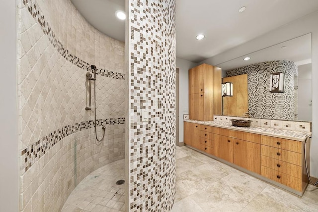 bathroom with decorative backsplash, a shower, and vanity