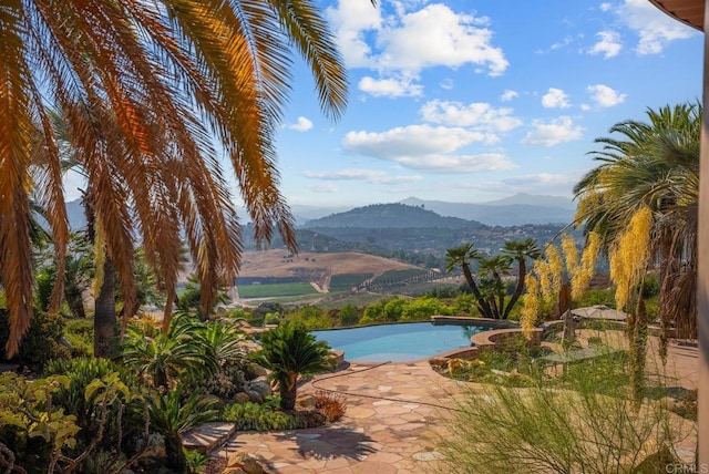 view of swimming pool with a patio area and a mountain view