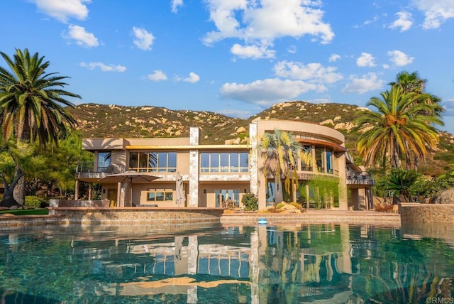 back of house with a balcony and a mountain view