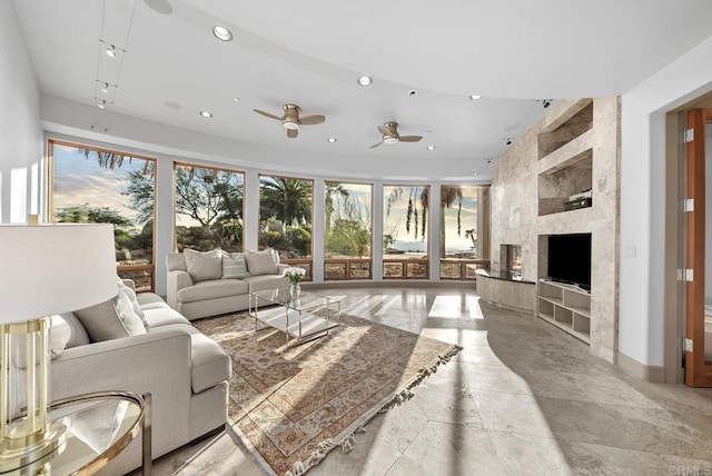 living room with a fireplace, ceiling fan, and a wealth of natural light