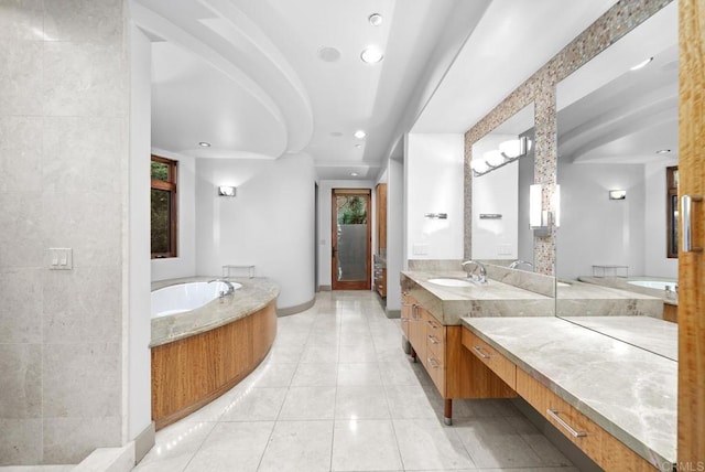 bathroom with tile patterned flooring, a tub to relax in, and vanity