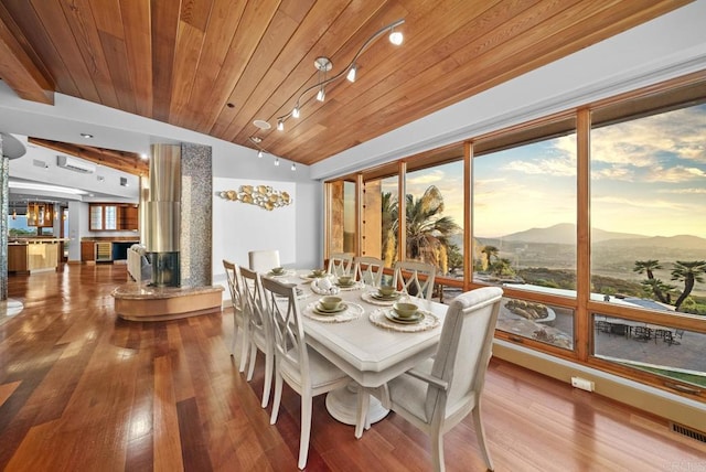 dining area with wooden ceiling, lofted ceiling, a mountain view, and hardwood / wood-style flooring