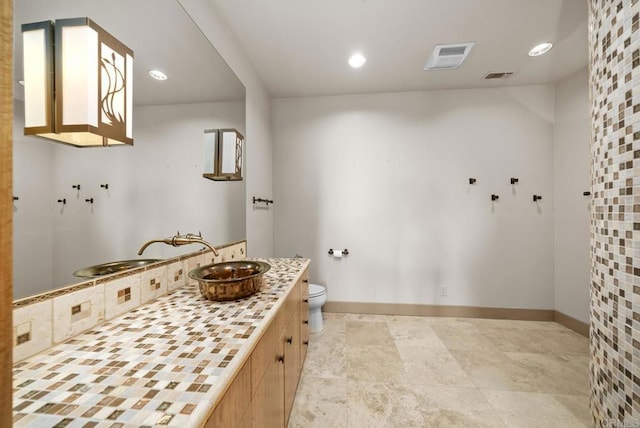 bathroom with backsplash, vanity, and toilet