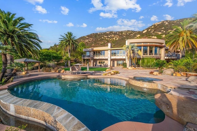 view of pool with a patio, an in ground hot tub, and a mountain view