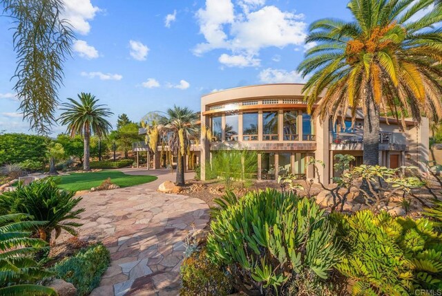 back of property featuring a balcony and a yard