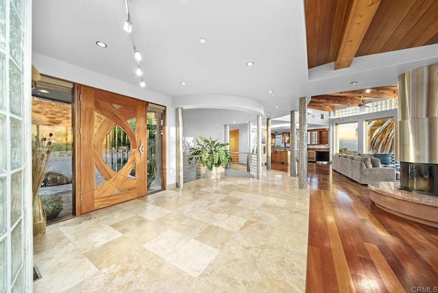 entryway featuring decorative columns, beam ceiling, and french doors