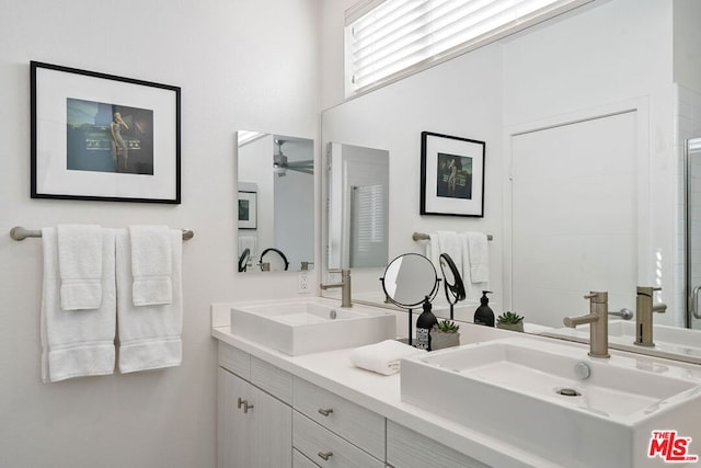 bathroom featuring a shower with door, ceiling fan, and vanity