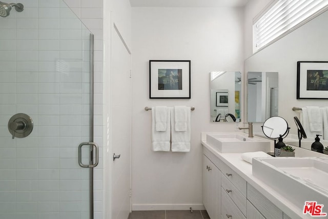 bathroom featuring a shower with door, vanity, tile patterned flooring, and ceiling fan