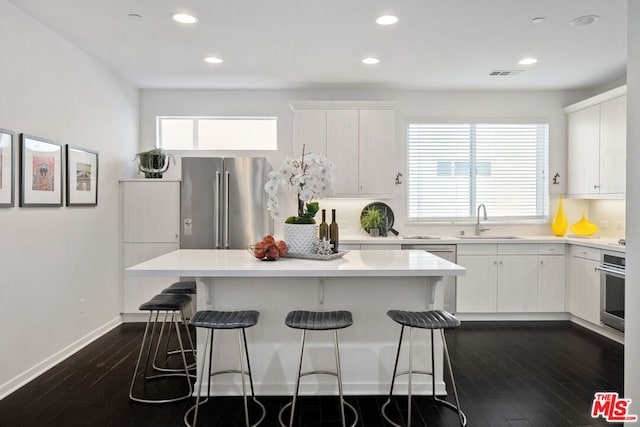 kitchen featuring sink, white cabinets, a center island, and appliances with stainless steel finishes