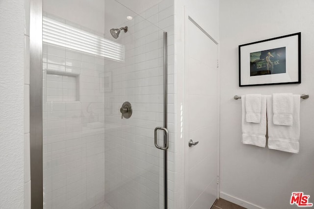 bathroom featuring a shower with door