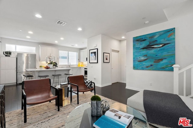 living room featuring sink and light hardwood / wood-style flooring