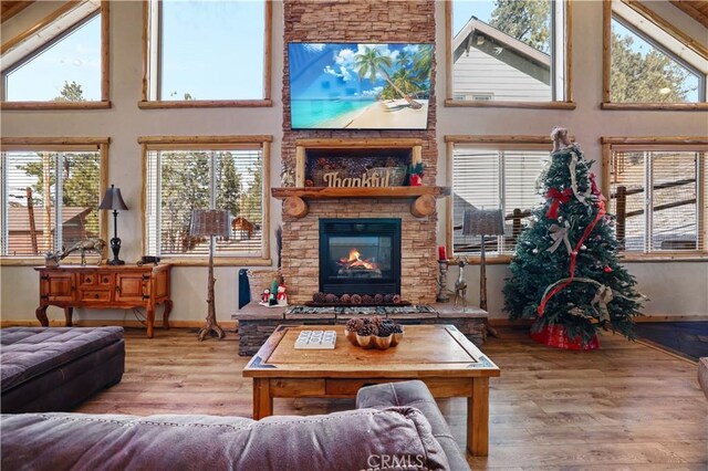 interior space with a towering ceiling, a fireplace, and hardwood / wood-style flooring