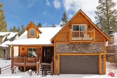 log-style house with a balcony and a garage