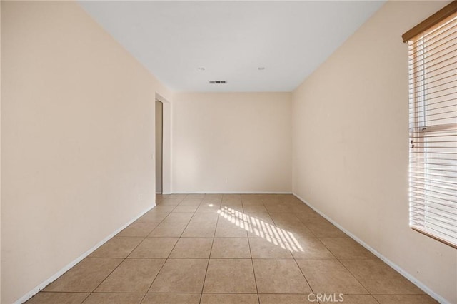 spare room with light tile patterned flooring and a wealth of natural light