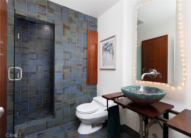 full bath with a sink, a tile shower, and toilet