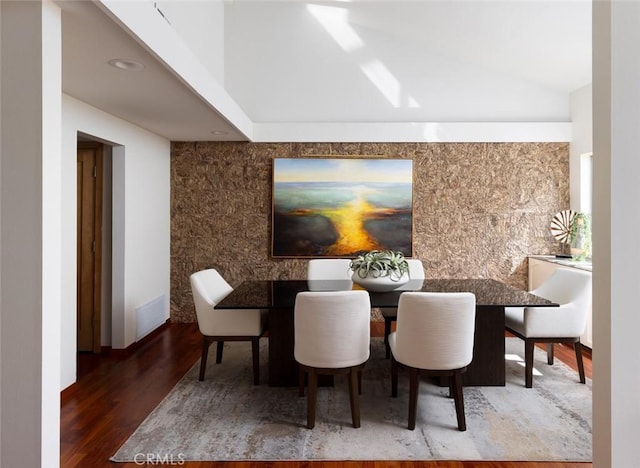 dining area featuring lofted ceiling, visible vents, and wood finished floors