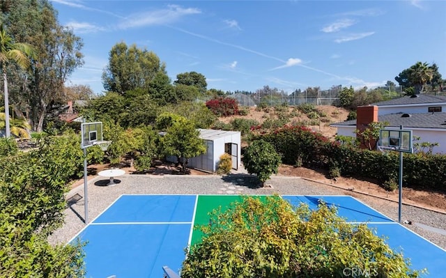 view of sport court with basketball court and a storage shed