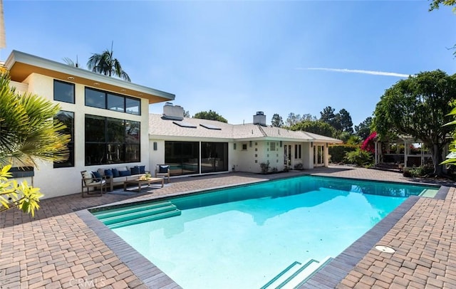 outdoor pool with a patio area and an outdoor living space