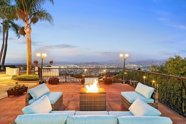 patio terrace at dusk featuring an outdoor living space with a fire pit