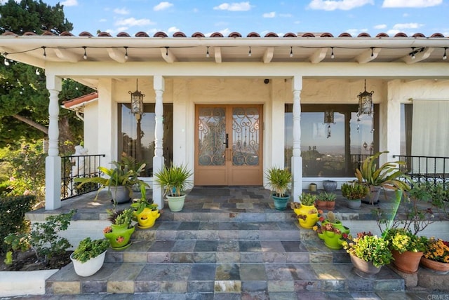 property entrance featuring a porch and french doors