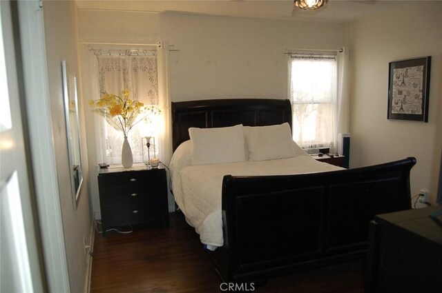 bedroom with dark hardwood / wood-style flooring